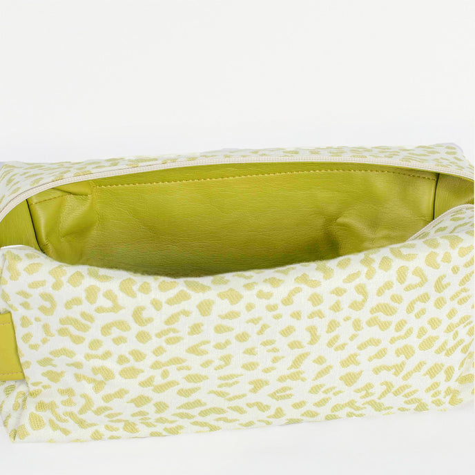 A lime green luxury leather alternative interior on a green and white print pattern toiletry kit named after Ashley 