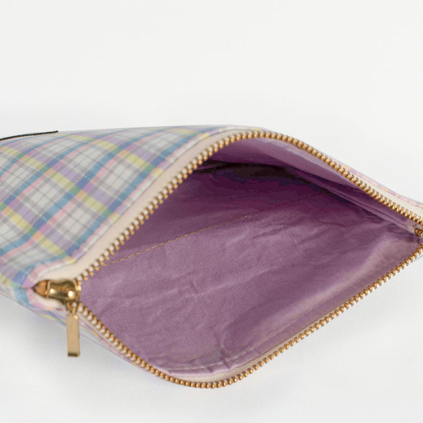 A purple fabric interior with a gold tone zipper on a purple plaid exterior named after Ashley 