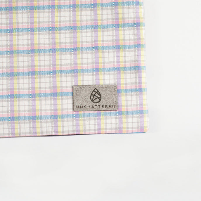 A gray label on a purple with blue, yellow and white plaid zip pouch named after Ashley 