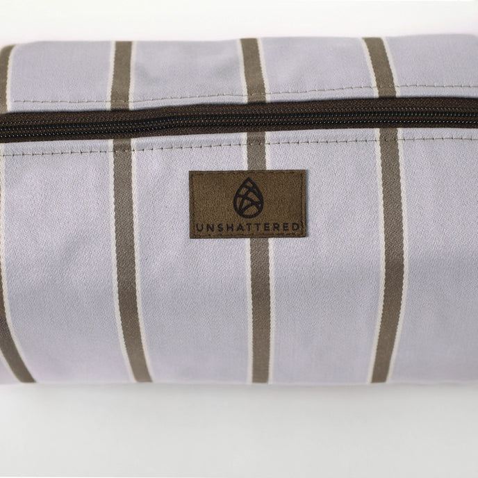 Close-up of a purple striped toiletry  with a zipper and logo on a white background named after Asia 