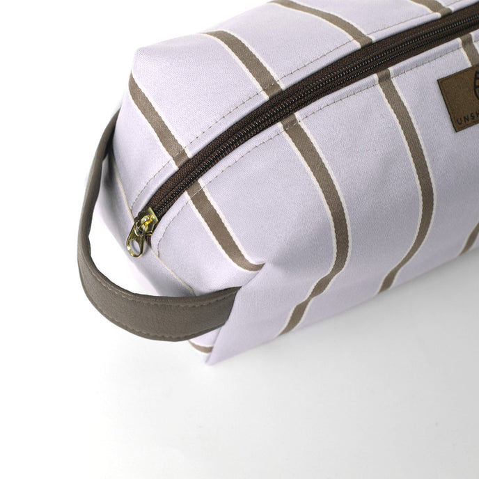 Purple toiletry bag with brown stripes and zipper partially open on a white background named after Asia 