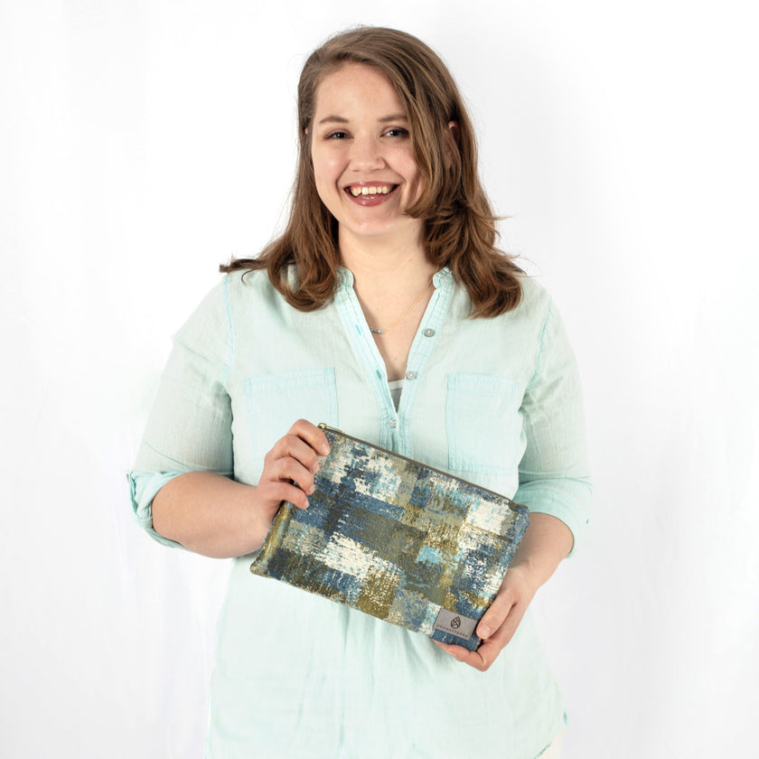 Woman holding a patterned large zip pouch against a white background