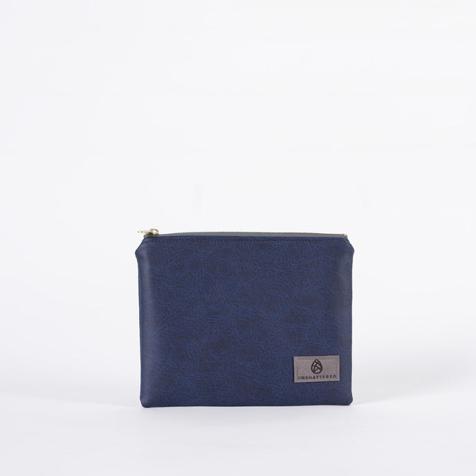 Black and blue luxury leather alternative zip pouch with a gray Unshattered label in the right corner.