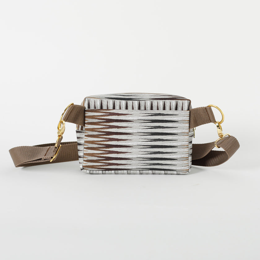 Back drop in pocket on an errand bag handcrafted from upcycled vinyl in a brown chevron pattern with brown straps and gold hardware named after Sally