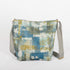 Back of a multi-color blue, green and white tote with a gray strap and gold-tone hardware
