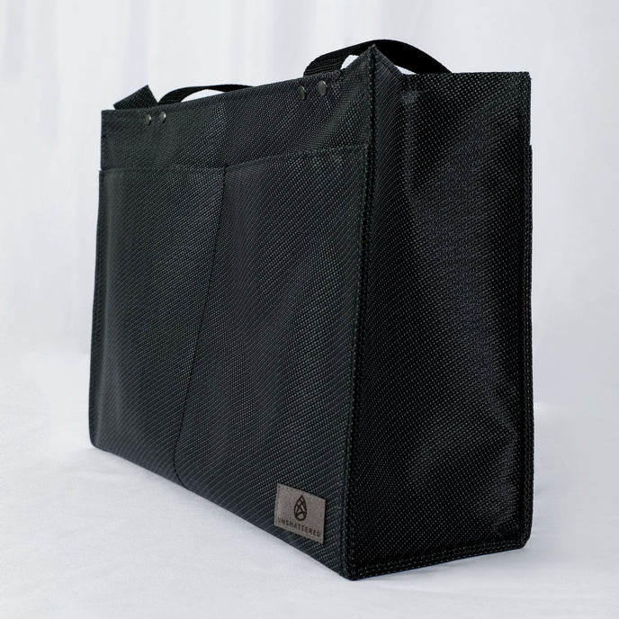 A gray label with two front pockets on the black zippered shopper tote 