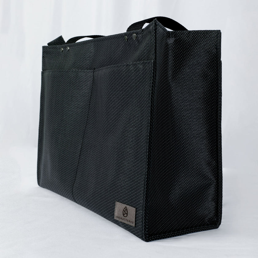 A gray label with two front pockets on the black zippered shopper tote 