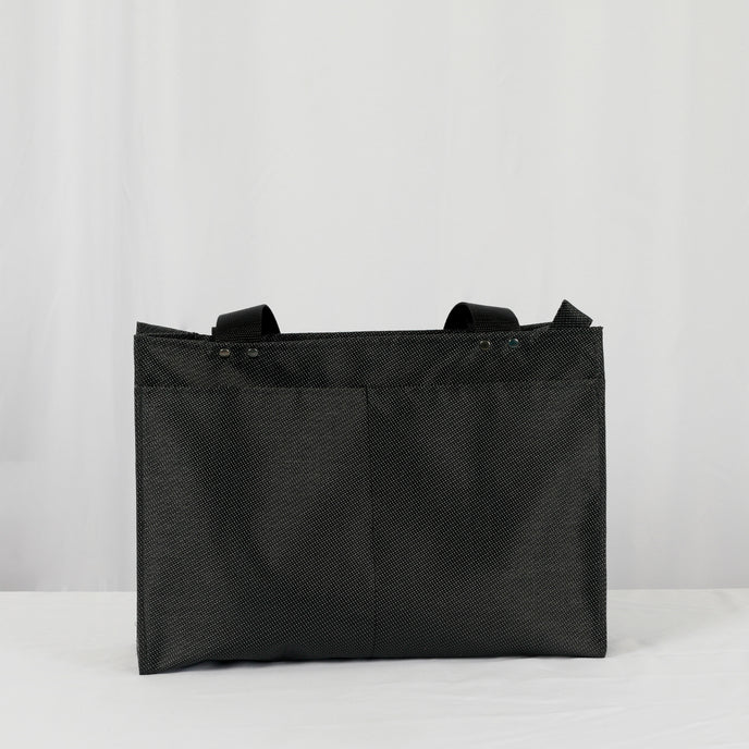 A black zippered shopper tote with two back pockets on the exterior with black hardware 