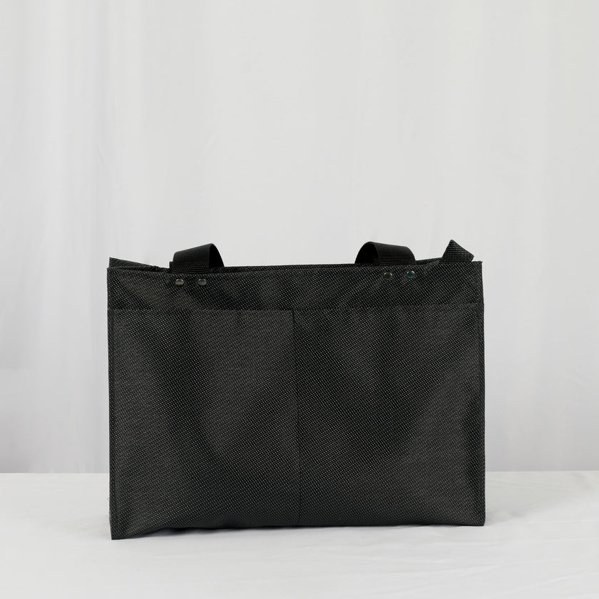 A black zippered shopper tote with two back pockets on the exterior with black hardware 