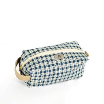 A blue and white plaid toiletry kit with a tan zipper and hardware, displayed against a white background.