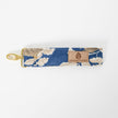Floral patterned keychain with 'Unshattered' brand label on a white background