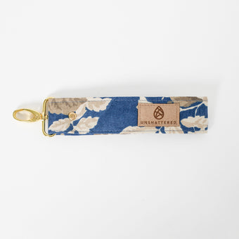 Floral patterned keychain with 'Unshattered' brand label on a white background