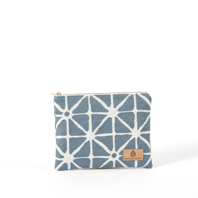 Blue and white geometric patterned pouch named Erica with a suede Unshattered label on a white background 