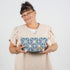 Person holding a blue geometric makeup pouch against a white background
