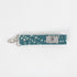 Bright and practical, this teal fabric wristlet key clip features a playful dotted pattern and sleek silver-tone hardware.