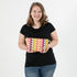 Woman holding a colorful geometric-patterned makeup  against a white background named after Brenda