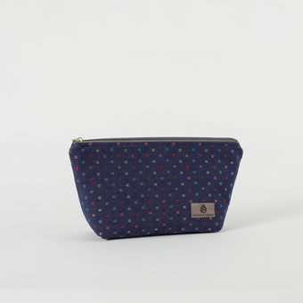 A blue cosmetic makeup bag with a geometric pattern and a zip closure, displayed against a white background.