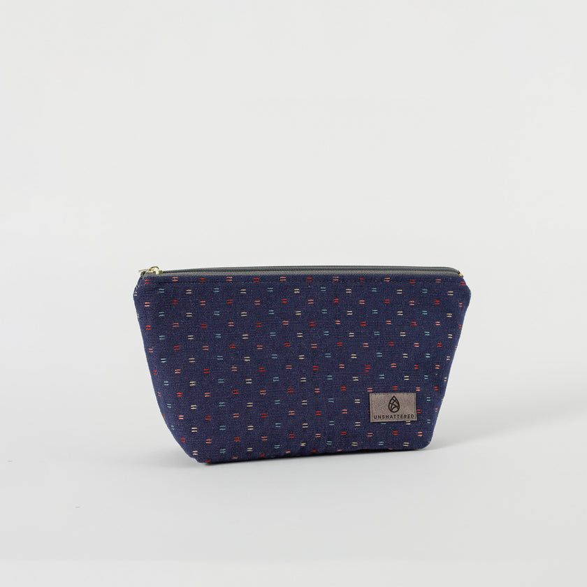 A blue cosmetic makeup bag with a geometric pattern and a zip closure, displayed against a white background.