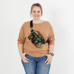 Person wearing a camouflage errand crossbody bag on a white background
