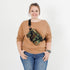 Person wearing a camouflage errand crossbody bag on a white background