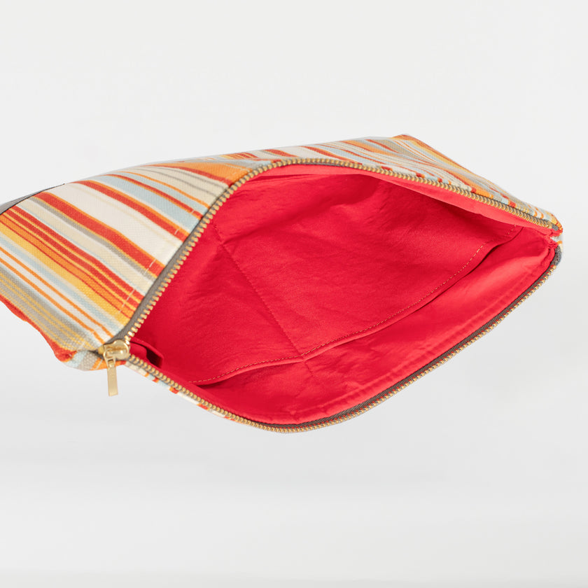 A red interior with two pockets on a striped large zip pouch named after Candy 