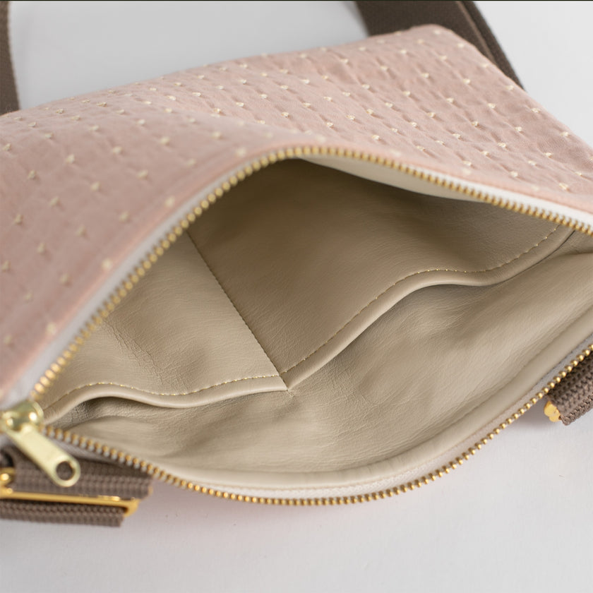 A tan luxury leather alternative interior on this pink a yellow dotted crossbody bag 