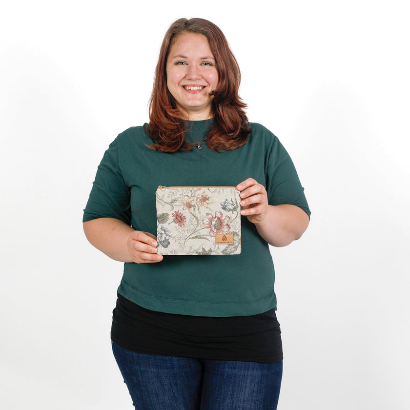 Woman holding a floral-patterned pouch against a white background named after Cathy 