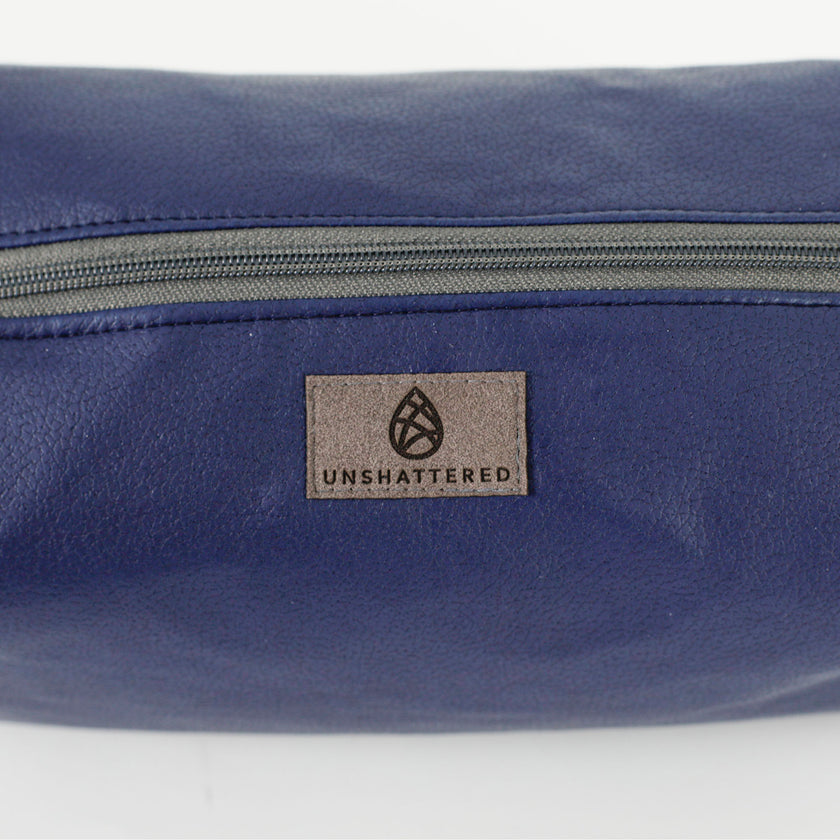 A gray Unshattered label on blue luxury leather alternative toiletry kit named after Cherisse