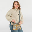 A woman wearing a multicolored geometric circle design zip pouch with gold-tone hardware named after Christina 