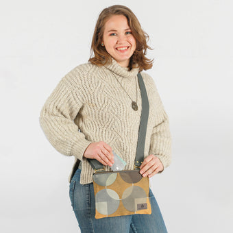 A woman wearing a multicolored geometric circle design zip pouch with gold-tone hardware named after Christina 