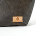 Close up of a tan suede Unshattered label on a brown luxury leather alternative makeup bag