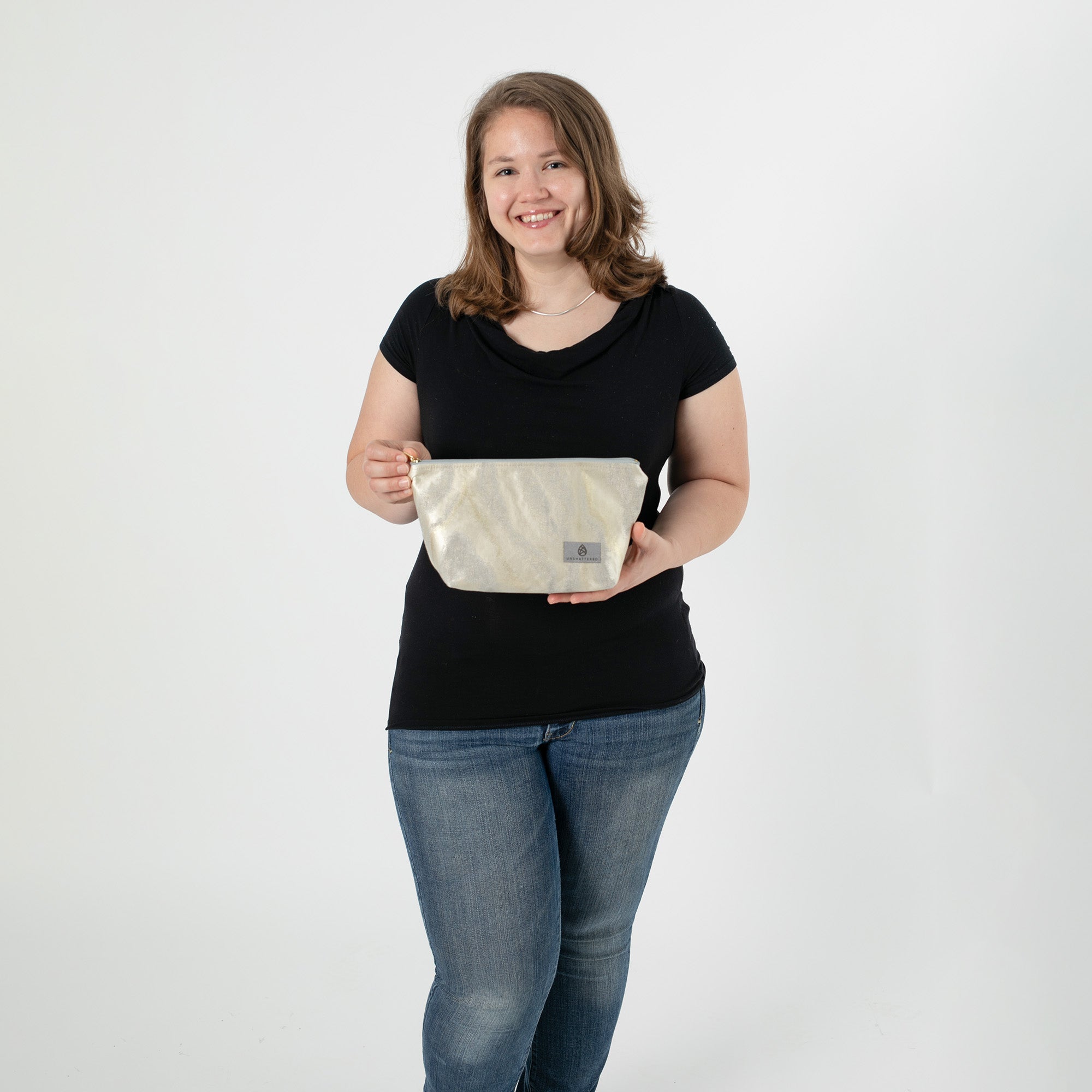 Woman holding silver and gold marbled makeup kit