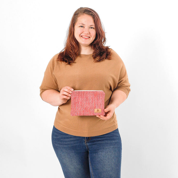 Woman holding a pink patterned pouch against a white background named after Dariene