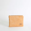 Beige suede pouch with a brand logo on a white background