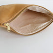 Interior of beige suede pouch with gold zipper on a light gray background