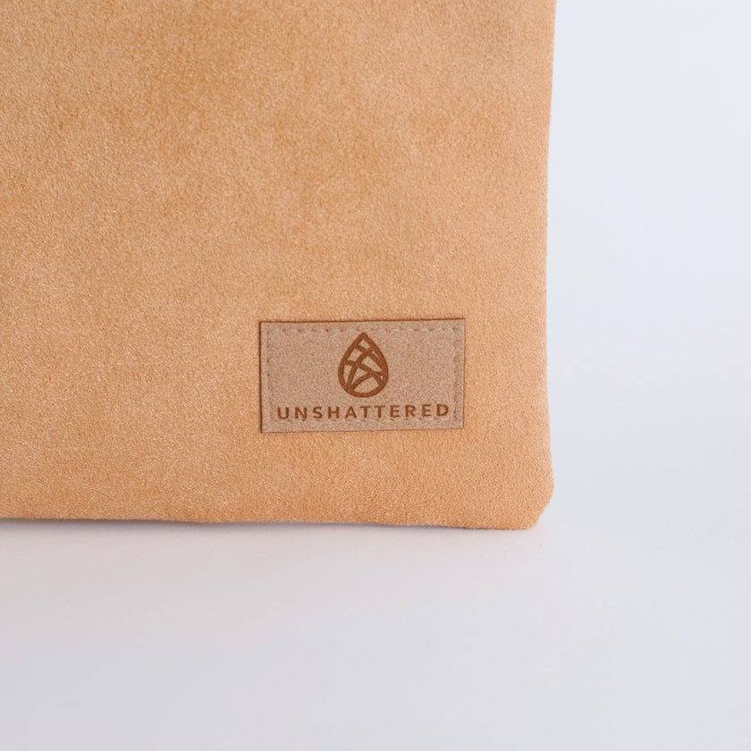 Beige fabric with 'Unshattered' brand logo on a light gray background
