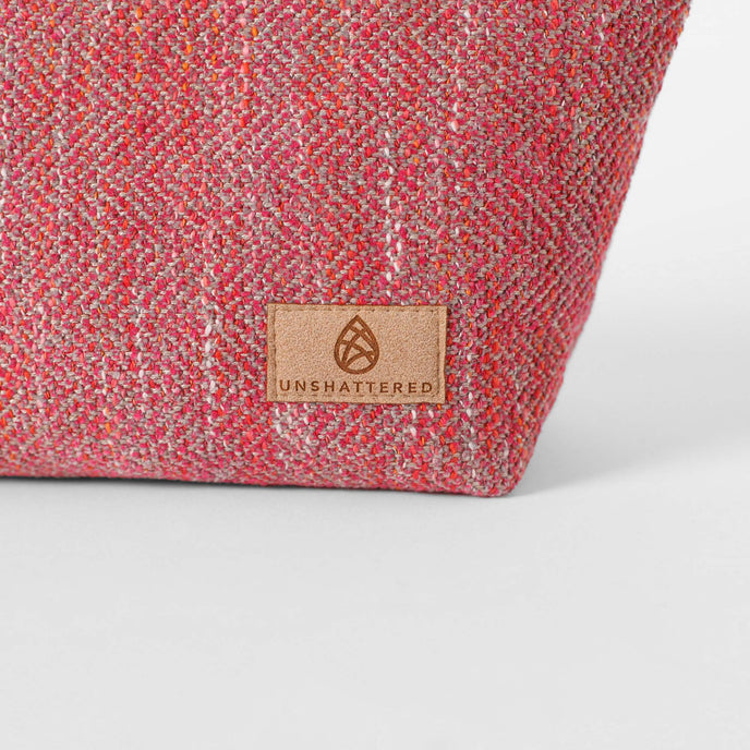 Pink  textured fabric with a tan label on a white background named after Dee