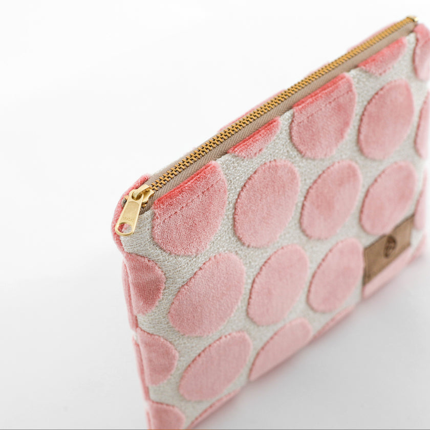 Pink dotted zippered pouch with gold zipper on a white background