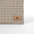 Tan suede label on a checked zippered pouch handcrafted from upcycled material