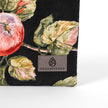 Gray suede Unshattered label on an upcycled floral-patterned fabric pouch with apples named Gloryann
