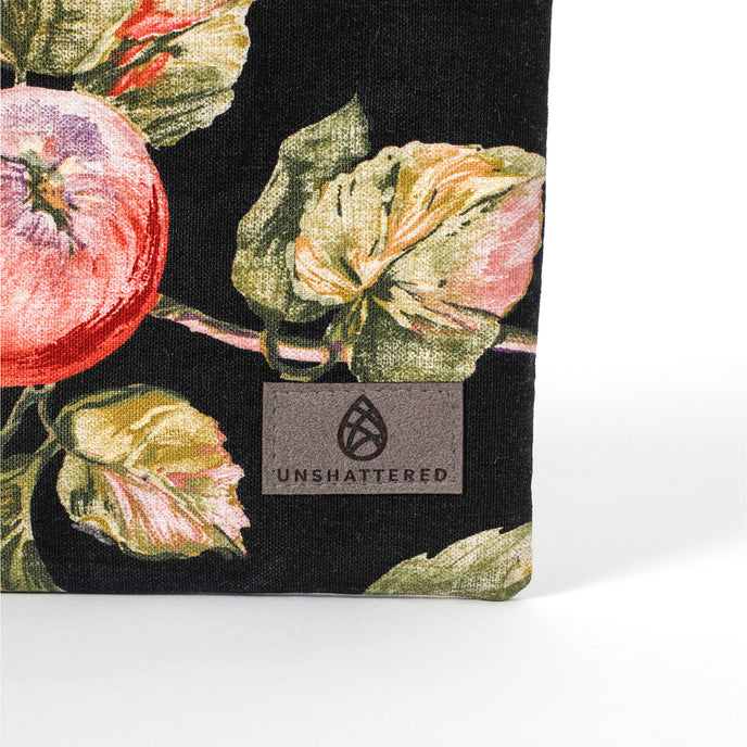 Gray suede Unshattered label on an upcycled floral-patterned fabric pouch with apples named Gloryann