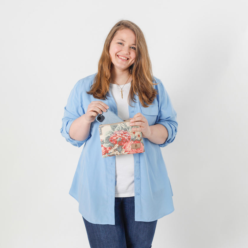 A woman holding a flower design zip pouch with a blue shirt and jeans  named after Diana