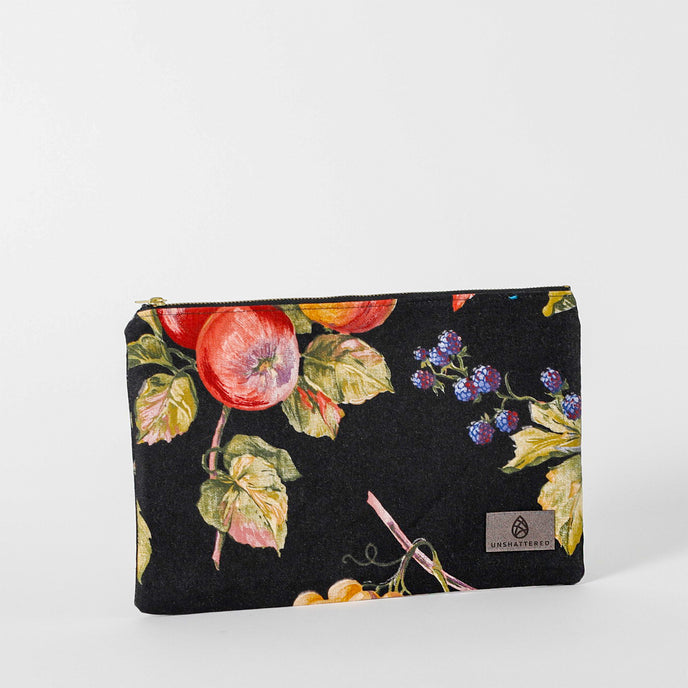A large black zip pouch with a vibrant floral and fruit print design, featuring red apples and green leaves named after Diane 