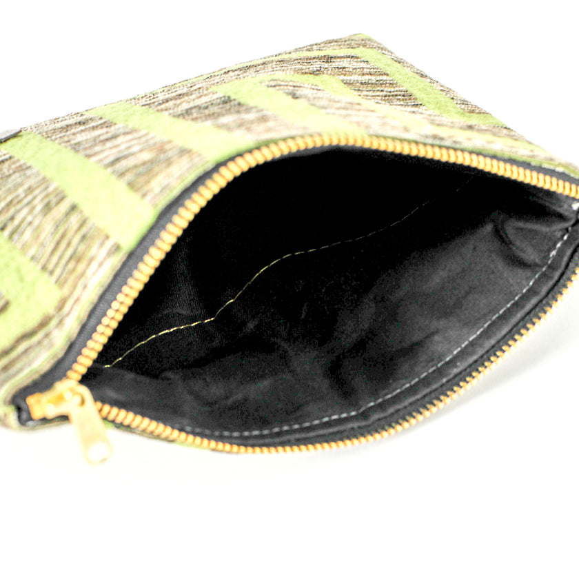 A black fabric interior of a lime green design zip pouch named after Eileen.