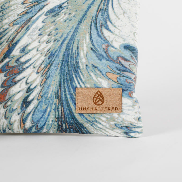 A detail shot of a tan Unshattered label in the bottom right corner of this Eliza Crossbody bag.
