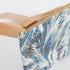 A teal whisper crossbody bag with gold tone hardware and a tan strap. 