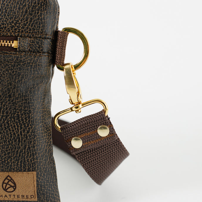 Close up of brown crossbody strap attached to brown 3-in-1 Bag