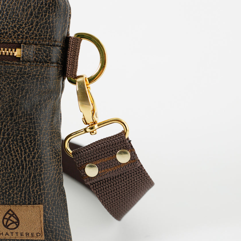 Close up of brown crossbody strap attached to brown 3-in-1 Bag