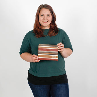 Woman in a green shirt holding a striped pouch