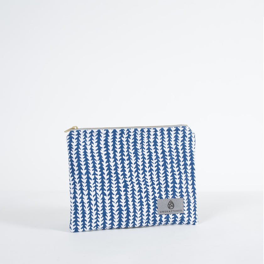 A blue and white pattern zip pouch with a gray Unshattered label on a white background 